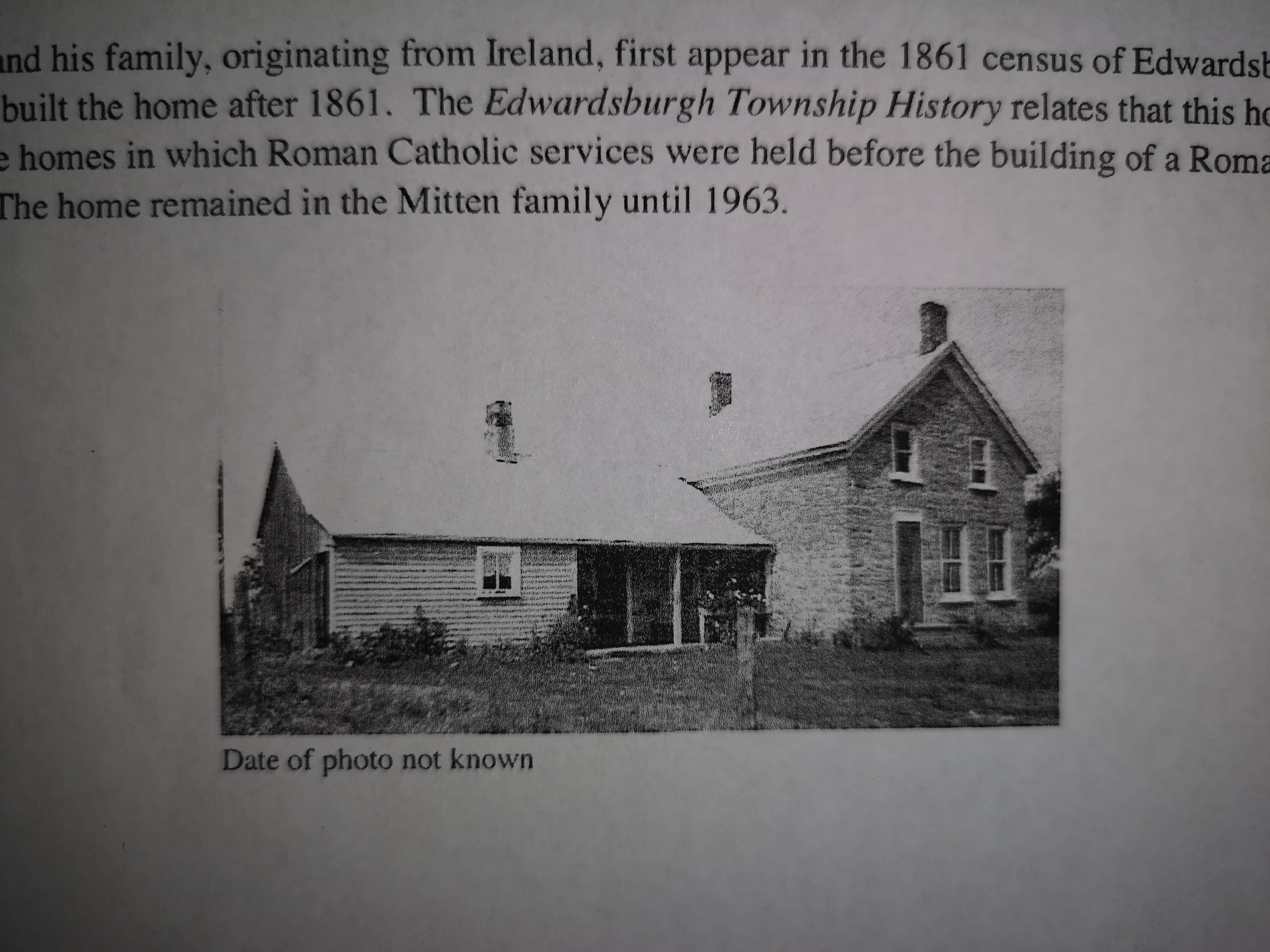 Historical book entry showing an early photograph of the stone farmhouse